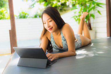 Portre güzel genç Asyalı kadın mutlu gülümseme kullanarak tablet veya