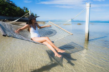Portre güzel genç Asyalı kadın etrafında hamak üzerinde oturuyor s