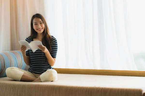 Retrato hermosa joven asiática mujer leyendo libro en en sofá en —  Fotos de Stock