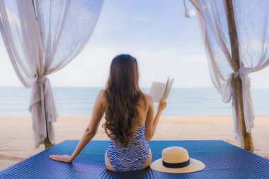 Portre güzel genç Asya kadın okuma kitap ile mutlu SMI