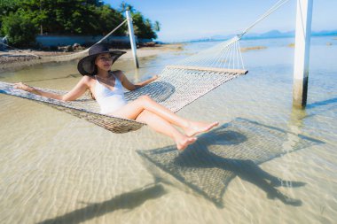 Portre güzel genç Asyalı kadın etrafında hamak üzerinde oturuyor s