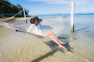 Portre güzel genç Asyalı kadın etrafında hamak üzerinde oturuyor s