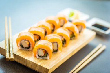 Somon Balık et suşi roll maki ahşap plaka üzerinde