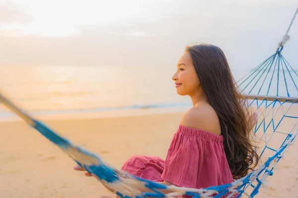 Retrato bela jovem mulher asiática sentado na rede com — Fotografia de Stock