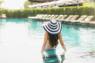 Portre güzel asya kadın mutlu gülümseme yüzme etrafında dinlenmek