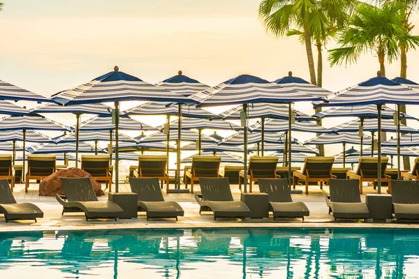 Parapluie et chaise canapé autour de la piscine extérieure à l'hôtel re — Photo