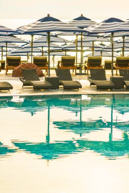 Otel re açık yüzme havuzu etrafında Şemsiye ve sandalye kanepe