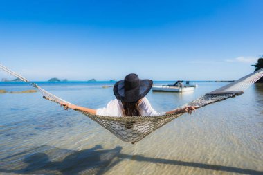 Portre güzel genç Asyalı kadın etrafında hamak üzerinde oturuyor s
