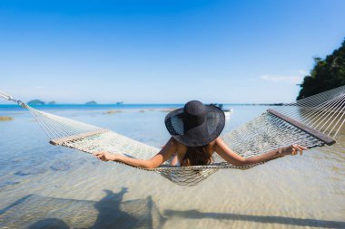 Portre güzel genç Asyalı kadın etrafında hamak üzerinde oturuyor s