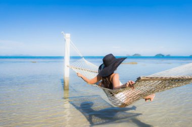 Portre güzel genç Asyalı kadın etrafında hamak üzerinde oturuyor s