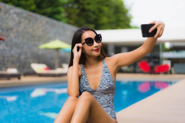 Portre güzel asya kadın açık çevresinde cep telefonu kullanarak