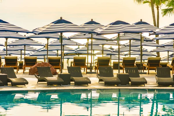 Зонт и диван-стул вокруг открытого бассейна в отеле — стоковое фото