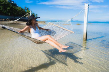 Portre güzel genç Asyalı kadın etrafında hamak üzerinde oturuyor s