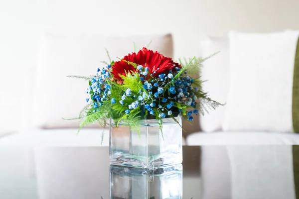 Váza květ na stole s polštáře na pohovce dekorace — Stock fotografie