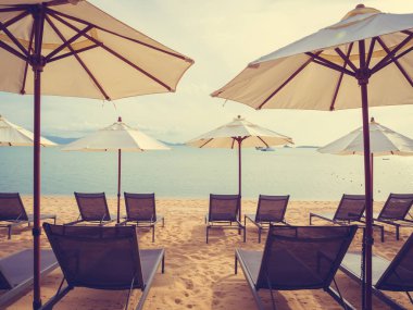 Şemsiye ve şezlong tropikal plaj deniz ve okyanus içinde doğumunda