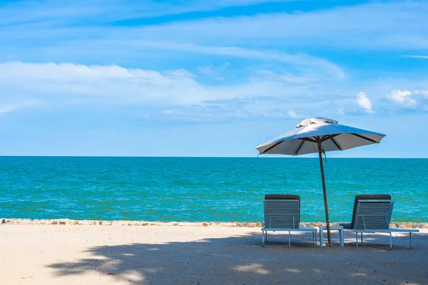 Krásný deštník a židle kolem plážového oceánu s modrým šskem — Stock fotografie