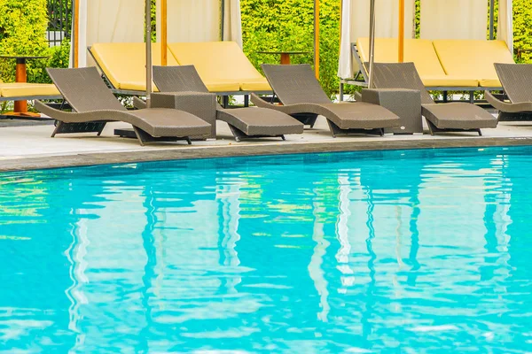 Guarda-chuva e sofá cadeira em torno da piscina exterior no hotel re — Fotografia de Stock