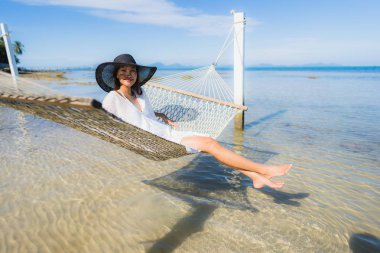 Portre güzel genç Asyalı kadın etrafında hamak üzerinde oturuyor s