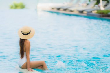 Portre genç asya kadın mutlu gülümseme yüzme kaka etrafında dinlenmek