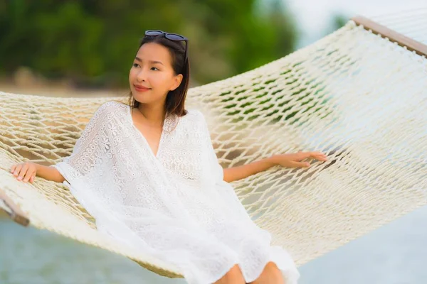 Portret mooie jonge Aziatische vrouw zittend op hangmat rond s — Stockfoto