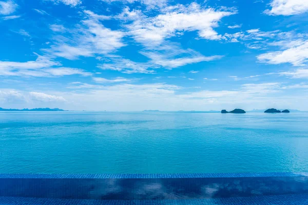 Bela piscina exterior com mar oceano na nuvem branca bl — Fotografia de Stock