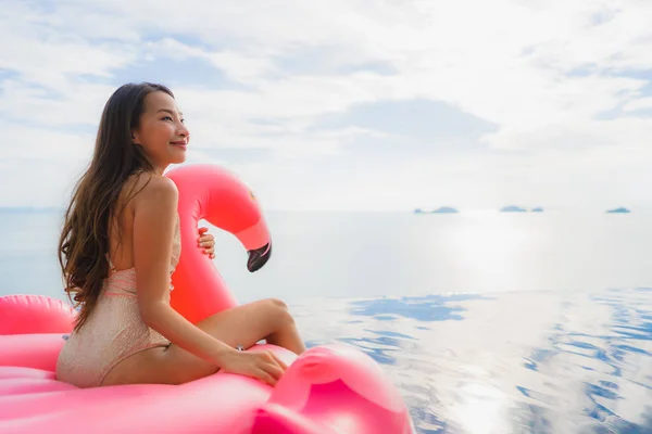 Portret jonge Aziatische vrouw op opblaasbare float Flamingo rond o — Stockfoto