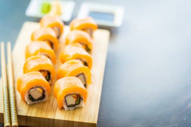 Somon Balık et suşi roll maki ahşap plaka üzerinde