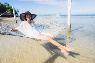 Portre güzel genç Asyalı kadın etrafında hamak üzerinde oturuyor s