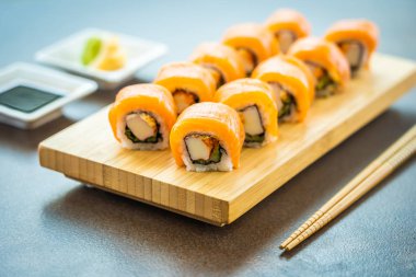 Somon Balık et suşi roll maki ahşap plaka üzerinde