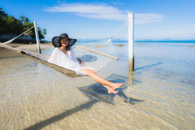 Portre güzel genç Asyalı kadın etrafında hamak üzerinde oturuyor s
