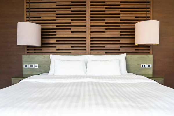 Schönes luxuriöses bequemes Kissen auf dem Bett mit Lampe — Stockfoto