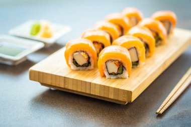 Somon Balık et suşi roll maki ahşap plaka üzerinde