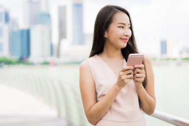 Asyalı kadın konuşmak veya metin için akıllı telefon veya cep telefonu kullanarak
