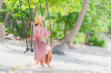 Portre genç asyalı kadın etrafında salıncak halat ve deniz üzerinde oturan 