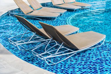 Boş sandalye bir koltuk almak ve açık yüzme po etrafında dinlenmek için