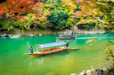 Akçaağaç ağaç yaprak ve etrafında tekne ile güzel Arashiyama Nehri 