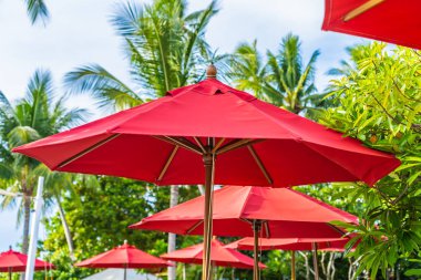 Sıcak açık yüzme havuzu etrafında güzel şemsiye ve sandalye