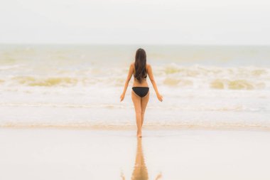 Portre güzel genç Asyalı kadın plaj se üzerinde bikini giymek