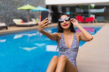 Portre güzel asya kadın açık çevresinde cep telefonu kullanarak