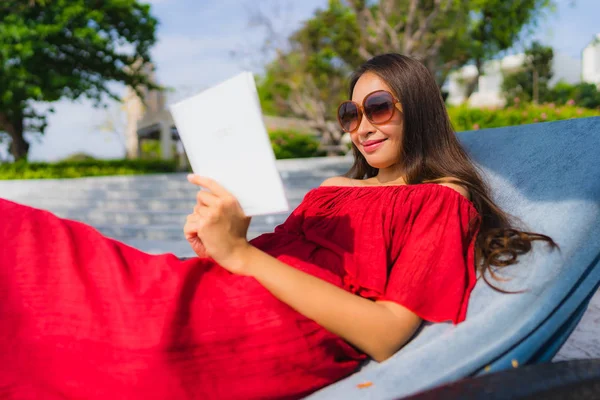 Portre güzel genç Asya kadın okuma kitap içinde yüzme Po