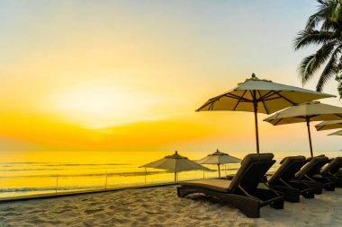 Şemsiye ve güzel plaj ve deniz gündoğumu, sandalyeye tim