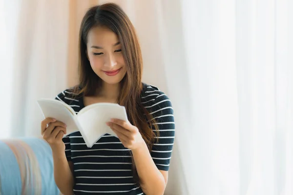 Portré szép fiatal ázsiai nő olvasás könyvet a kanapén — Stock Fotó