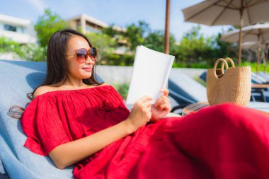 Portre güzel genç Asya kadın okuma kitap içinde yüzme Po