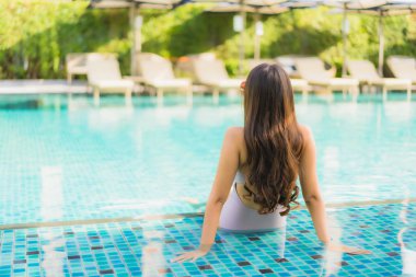 Portre güzel asya kadın mutlu gülümseme yüzme etrafında dinlenmek