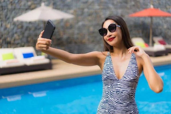 Retrato bela mulher asiática usando telefone celular ao redor ao ar livre — Fotografia de Stock