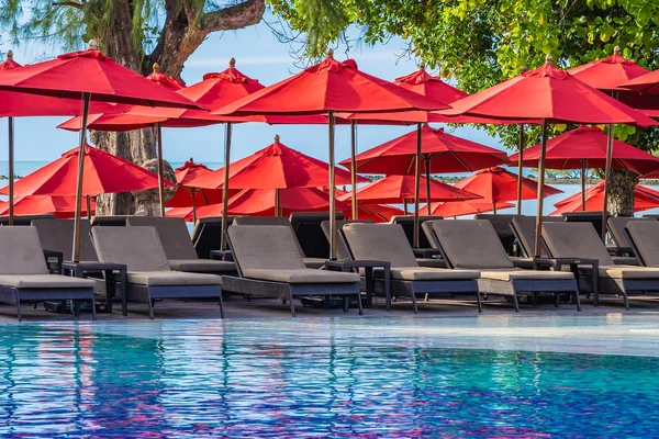 Hermoso paraguas y silla alrededor de la piscina al aire libre en caliente —  Fotos de Stock