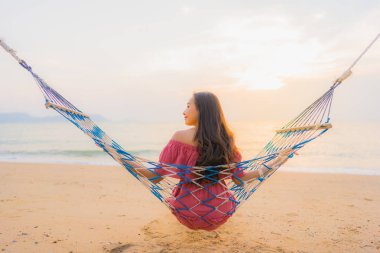 Dikey hamak ile oturan güzel genç Asyalı kadın