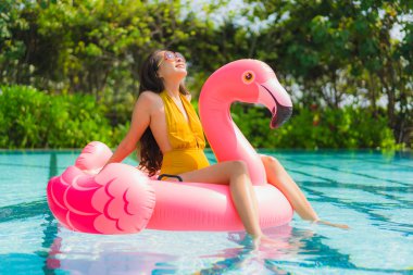 Portrait beautiful young asian woman on the flamingo inflatable  clipart