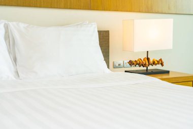 Hafif lamba ile yatak dekorasyonbeyaz rahat yastık