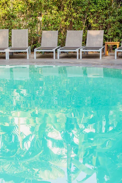 Silla vacía alrededor de la piscina en el complejo hotelero —  Fotos de Stock